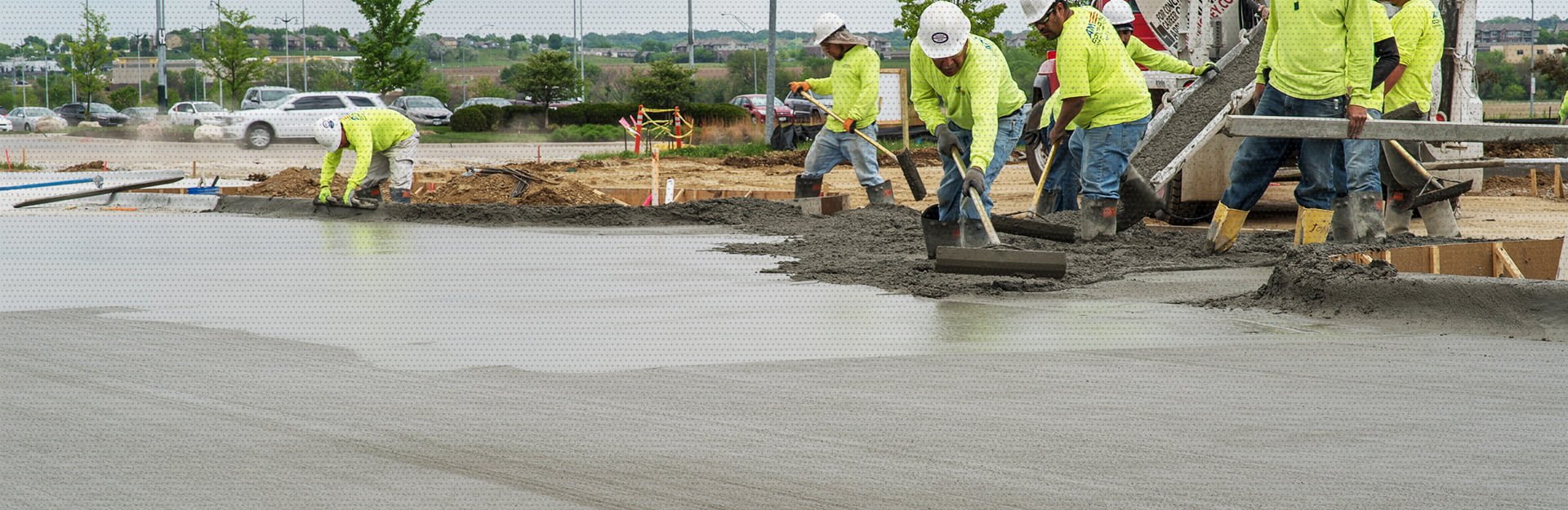The AM Contracting team preparing concrete that has been freshly laid down as they smooth it out against the wooden barrier and create curbs when necessary.